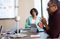 Un esaminatore che ascolta mentre un candidato risponde a una domanda durante un colloquio.