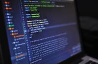 Der Bildschirm eines Laptops, auf dem Codes angezeigt werden, die für Berufe im IT-Sektor relevant sind.