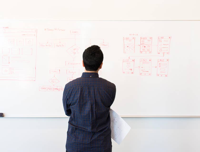 IT Architect looking at the network system design written at the whiteboard before implementing the upgrades