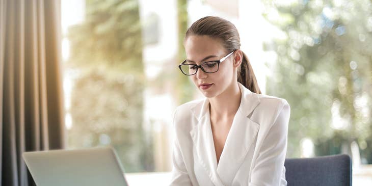 female IT director looking at her laptop while sitting inside her office.