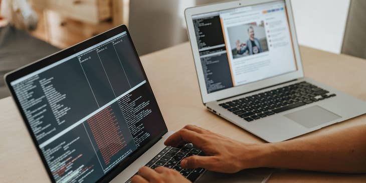 Java developer working on a program using his laptop.