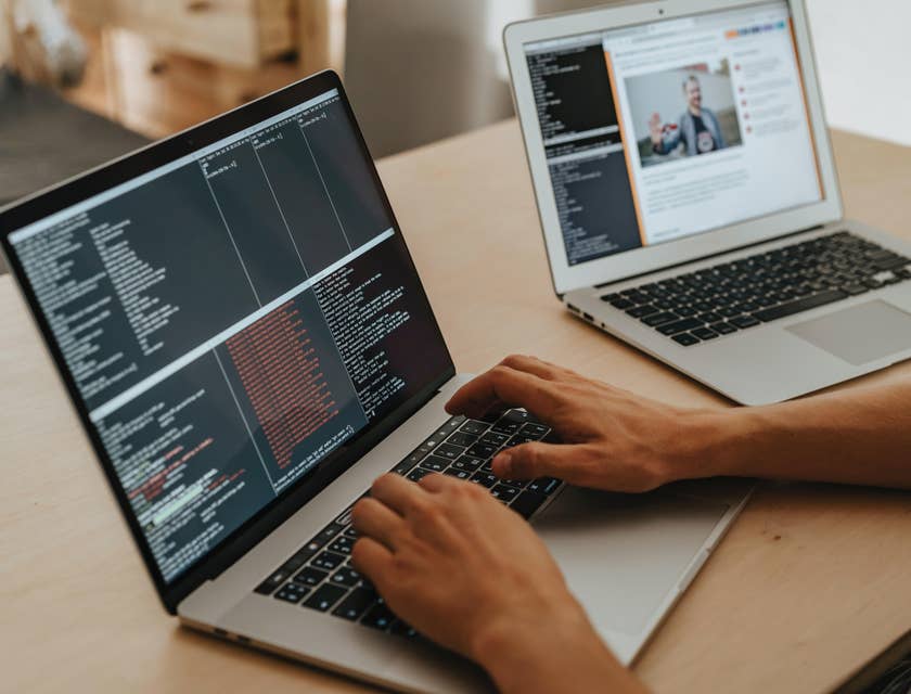 Java developer working on a program using his laptop.
