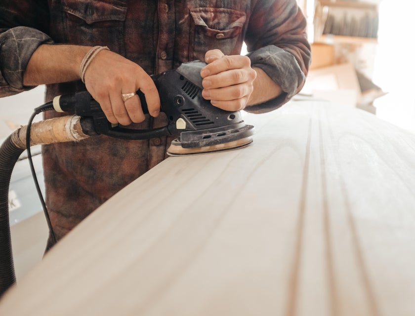 Journeyman carpenter sanding down a wooden board