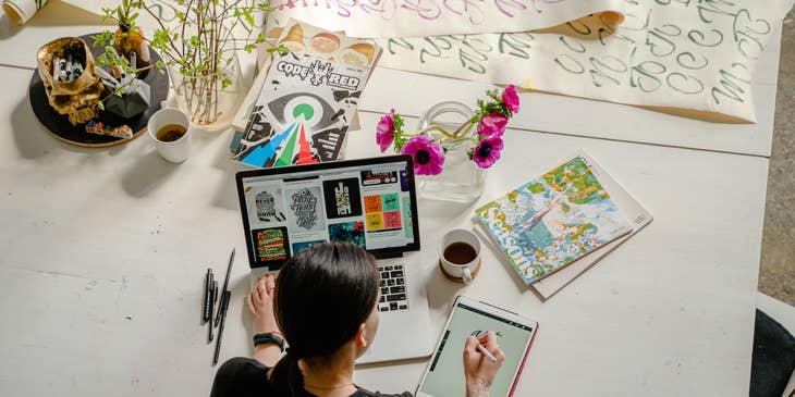 Junior graphic designer checking some logos for inspiration while creating her own art
