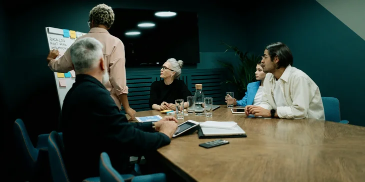 A junior project manager listening in a meeting with project managers.