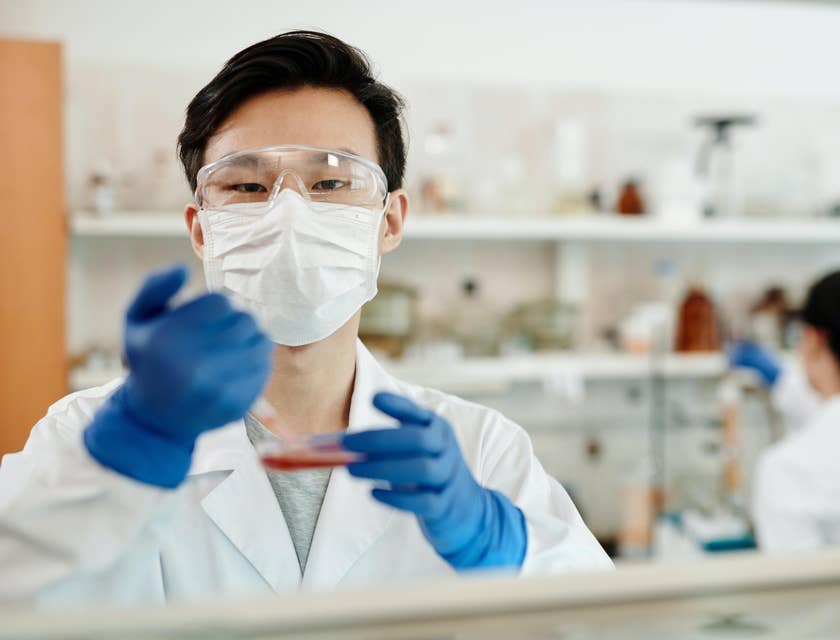 Lab assistant wearing safety gear running tests.