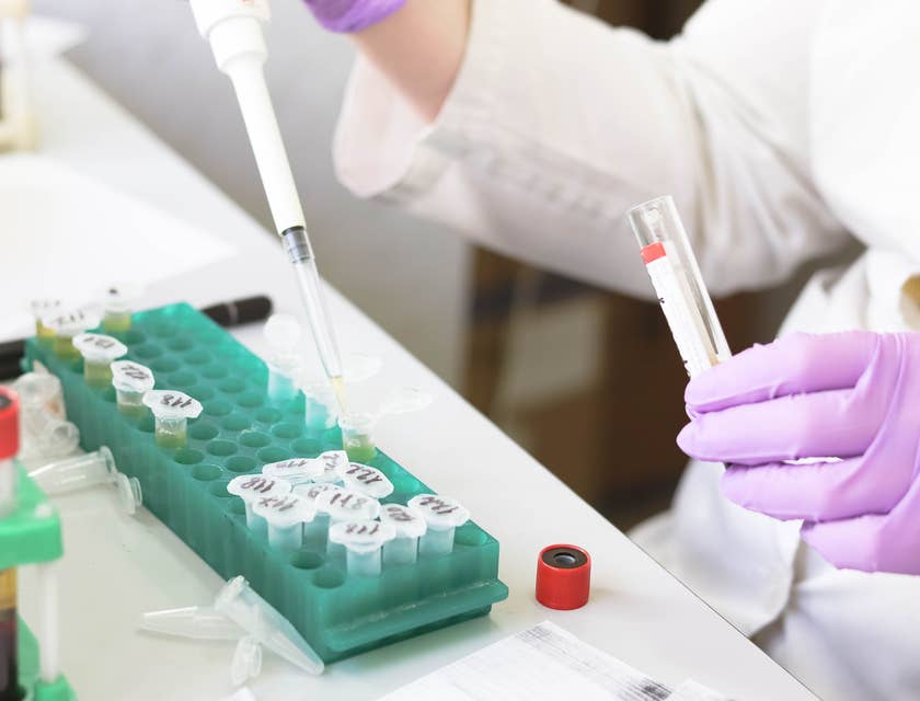 Lab technician holding a pipette and running tests
