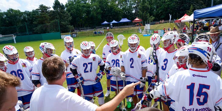 Man coaching a lacrosse team.