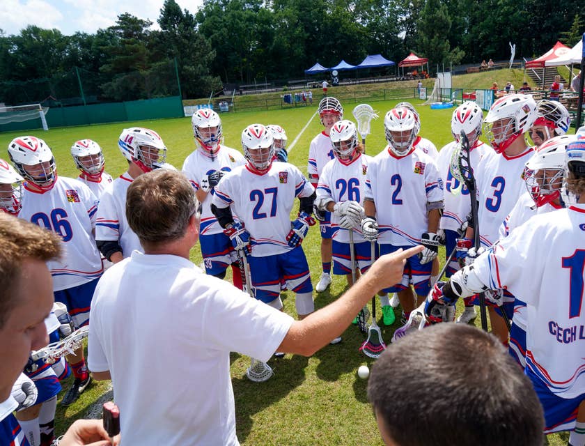Man coaching a lacrosse team.
