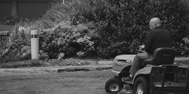 Lawn care technician mowing a lawn using a riding mower