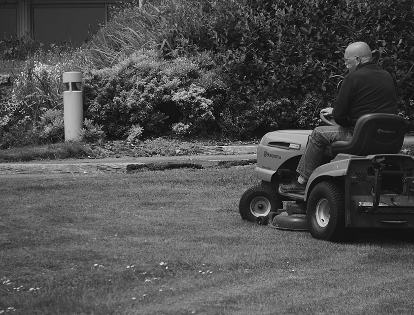 Lawn care technician mowing a lawn using a riding mower