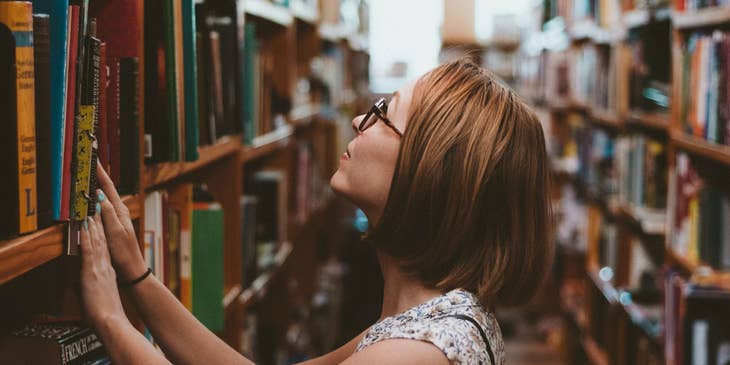Library assistant reshelving books