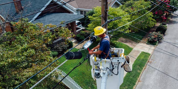 Line worker on a cherrypicker fixing cables