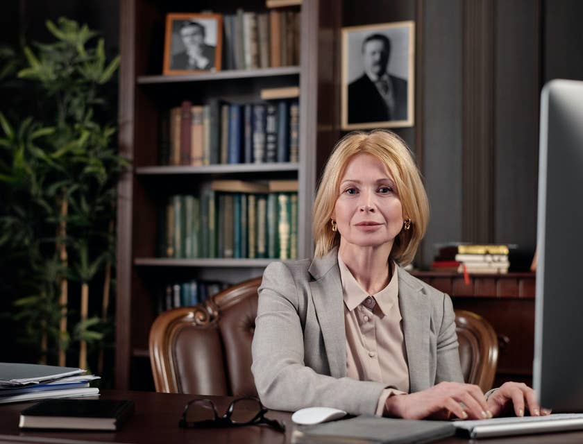 Photo of a loan officer sitting inside her office with her hands resting on the keyboard.