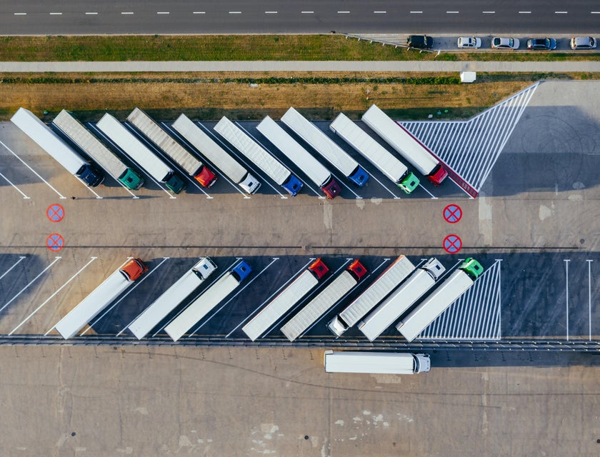 Top view of trucks stopping at a transportation depot.
