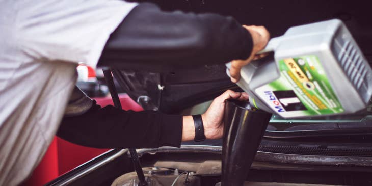 Lube Technician changing motor oil on a car
