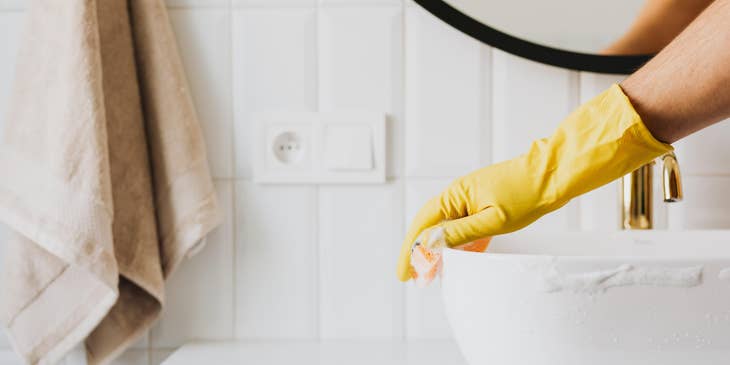 Maintenance Assistant cleaning a residential bathroom sink
