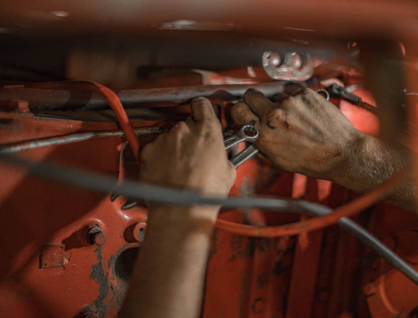 Maintenance Mechanic holding a wrench repairing a piece of equipment