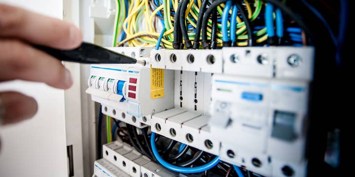 Maintenance Technician repairing an electric panel board.