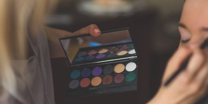 Makeup Artist applying eyeshadow on a client.