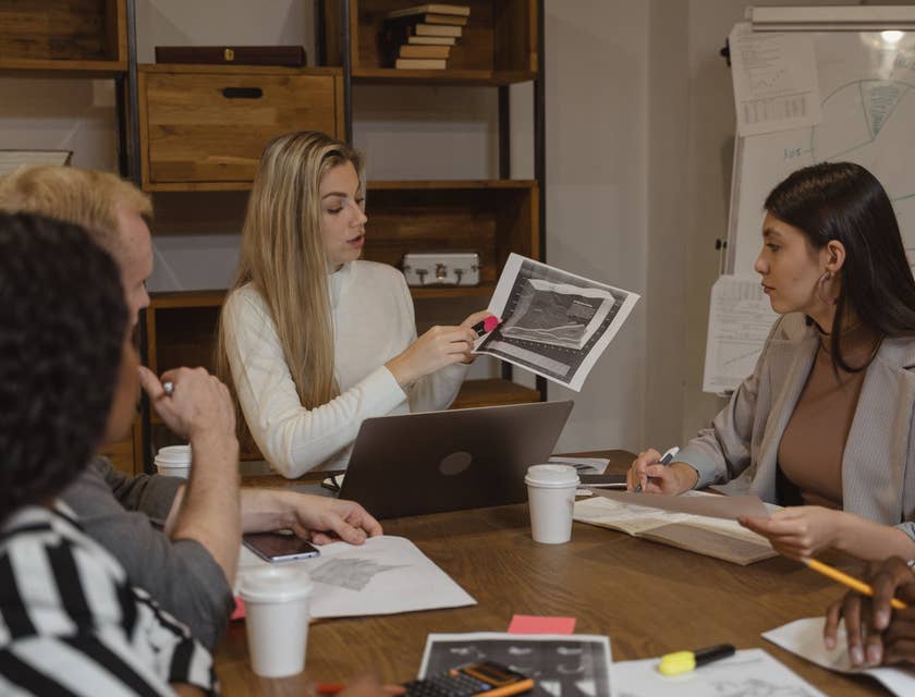 Management analyst showing the latest productivity report to members of the executive management