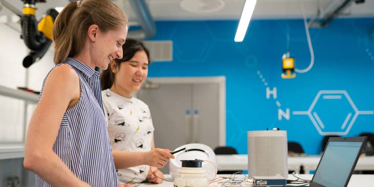 Manufacturing engineers testing a new product while standing next to the table with an open laptop