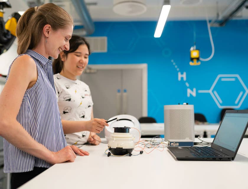 Manufacturing engineers testing a new product while standing next to the table with an open laptop
