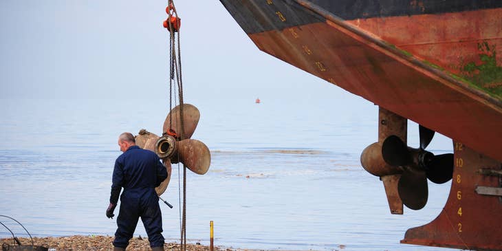 marine mechanic repairing a beached ship