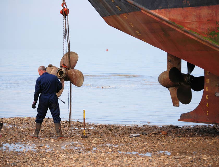 marine mechanic repairing a beached ship