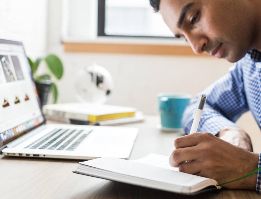 Marketing dtrategist conducting market research while taking key notes