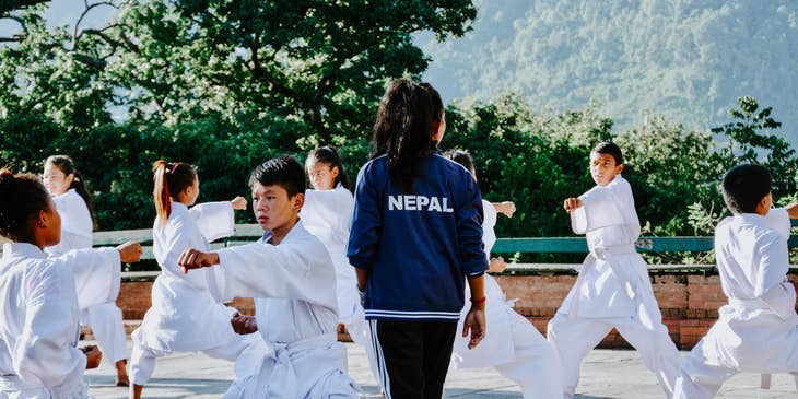 Martial arts instructor teaching a group of young students.