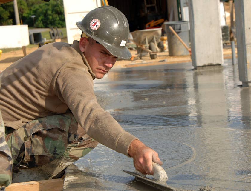 Mason leveling concrete on a construction site.