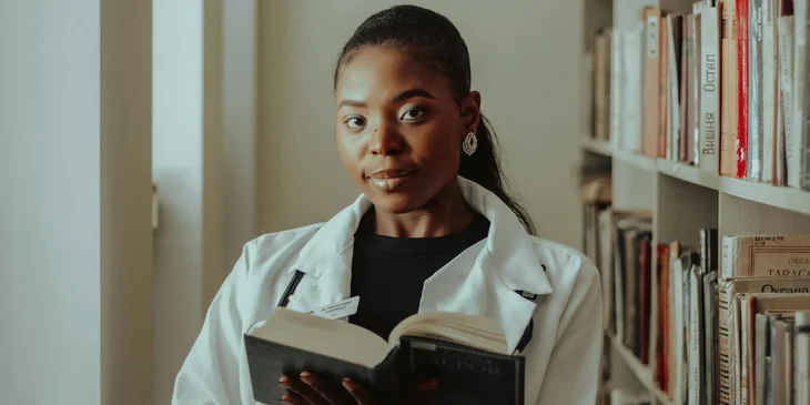 A medical anthropologist is conducting research by reading books.