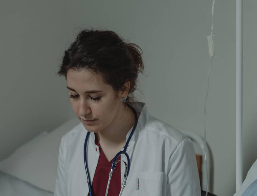 Medical assistant obtaining and recording patients' medical history.