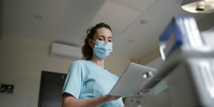 A medical assistant looking at a patients' chart.