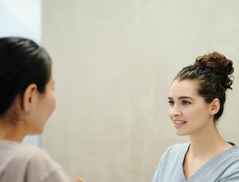 The medical receptionist greets and attends to a patient that has an appointment for the day.