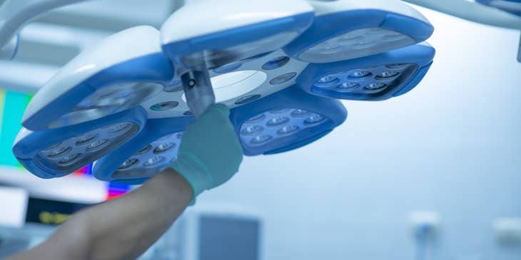 Medical-surgical nurse positioning the surgical lighting before the surgery.