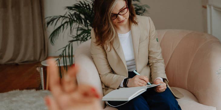 Mental health worker taking notes while having a conversation with a patient.