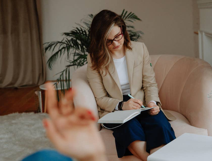 Mental health worker taking notes while having a conversation with a patient.