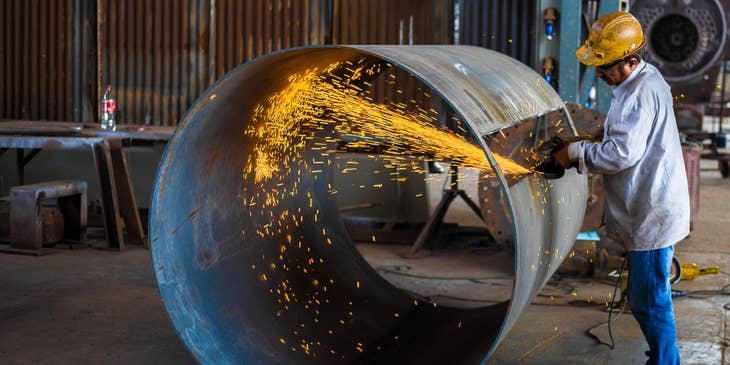 Metal fabricator cutting the metal according to the blueprint