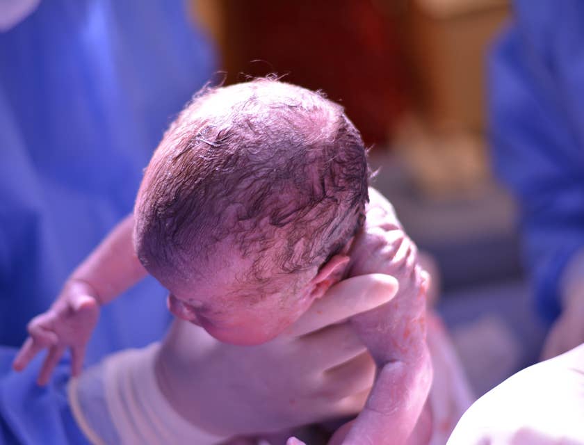 Midwife assists with childbirth in a hospital setting.