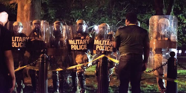 Military police officers lined up for duty outside a secured area during nighttime