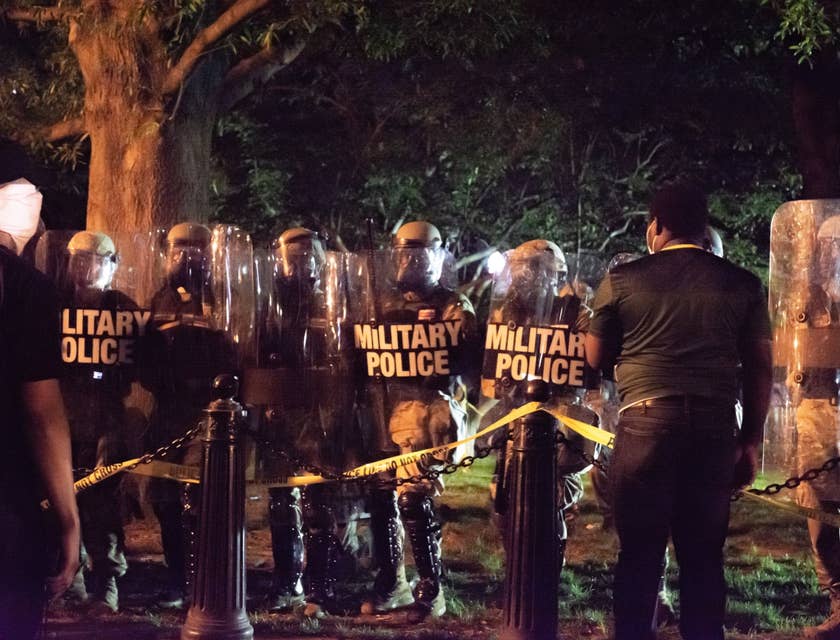Military police officers lined up for duty outside a secured area during nighttime