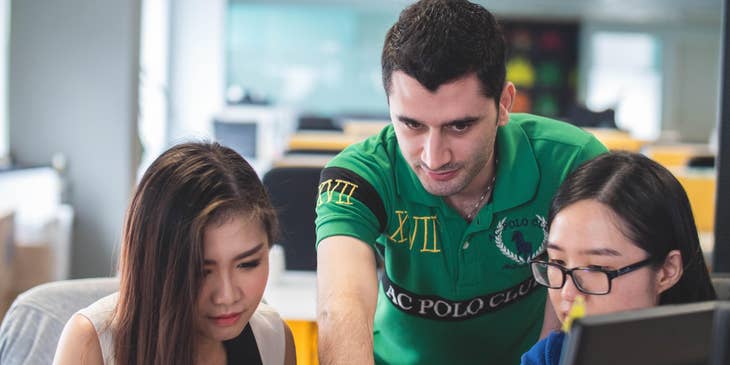 A team of mobile developers deliberating on the new system design as part of their team's project.
