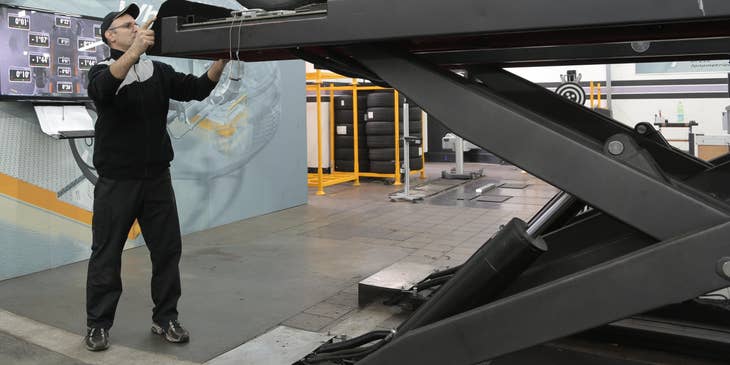 MOT tester checking on a black sedan.