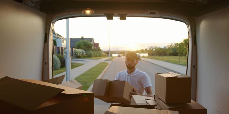 Mover carrying boxes into a moving van