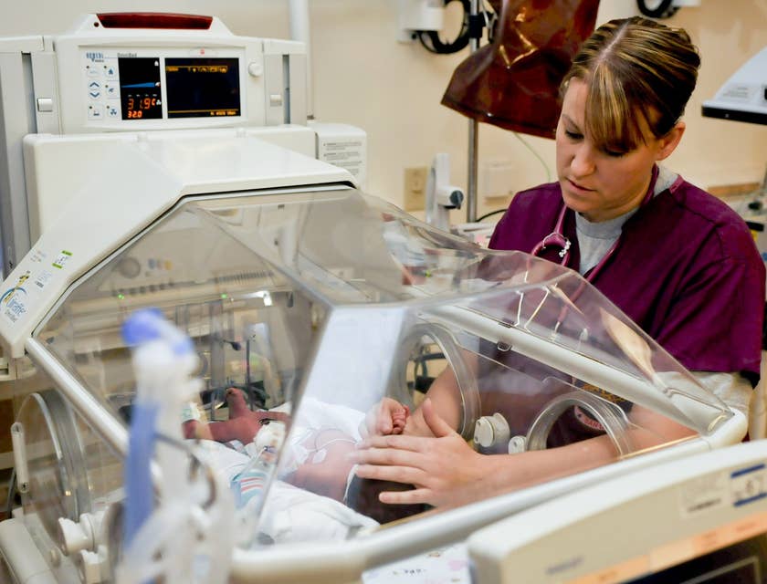Neonatal nurse caring for the infant in NICU.