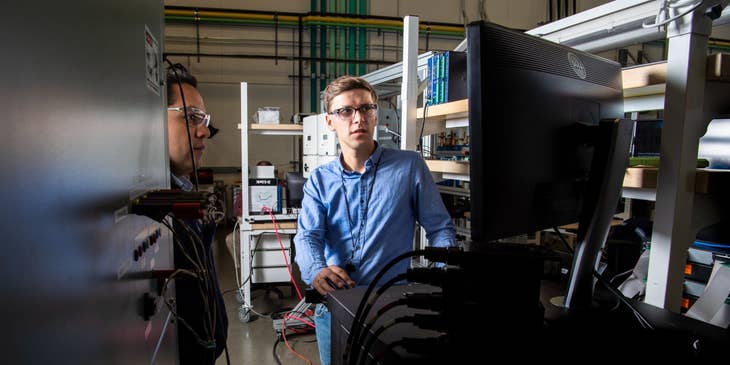 two network engineers doing a maintenance check on the company's computer network