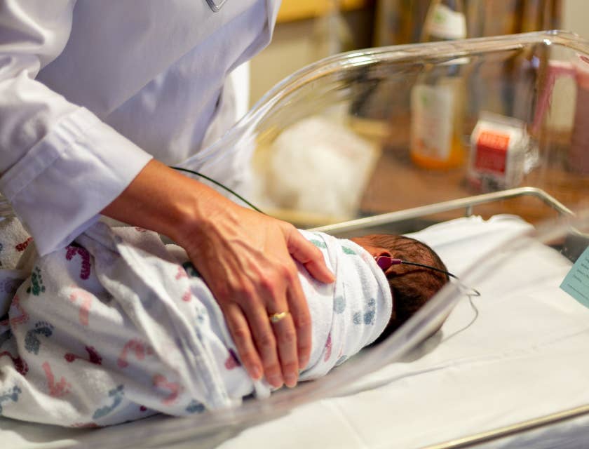 NICU nurse cares for the newborn on hearing test.