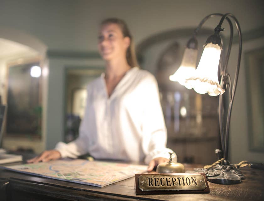 A female night auditor standing in the reception area smiling.